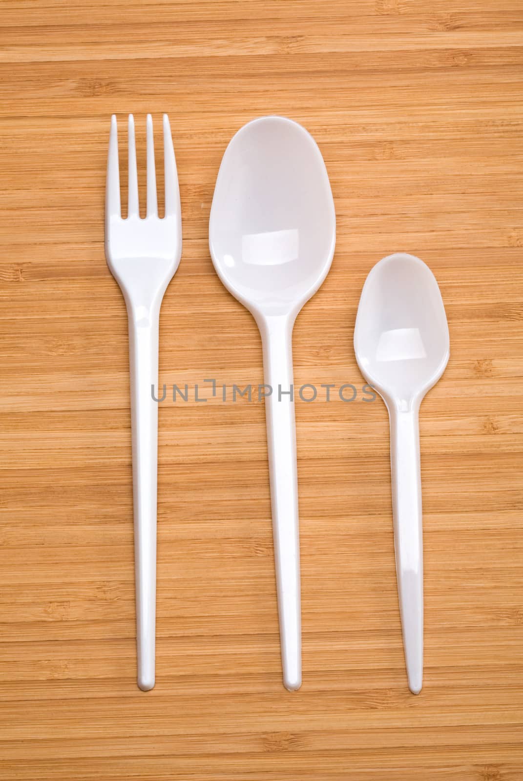 plastic disposable cutlery on a wooden background