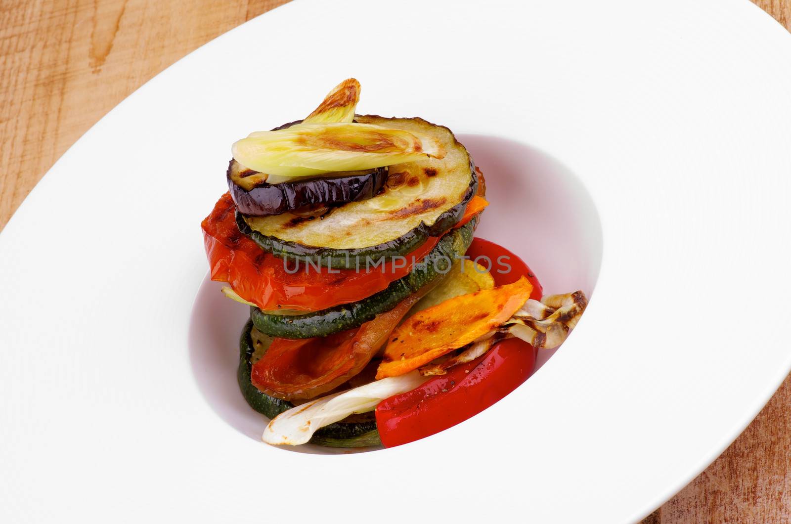 Delicious Traditional Ratatouille with Grilled Vegetables in White Plate closeup on Wooden background