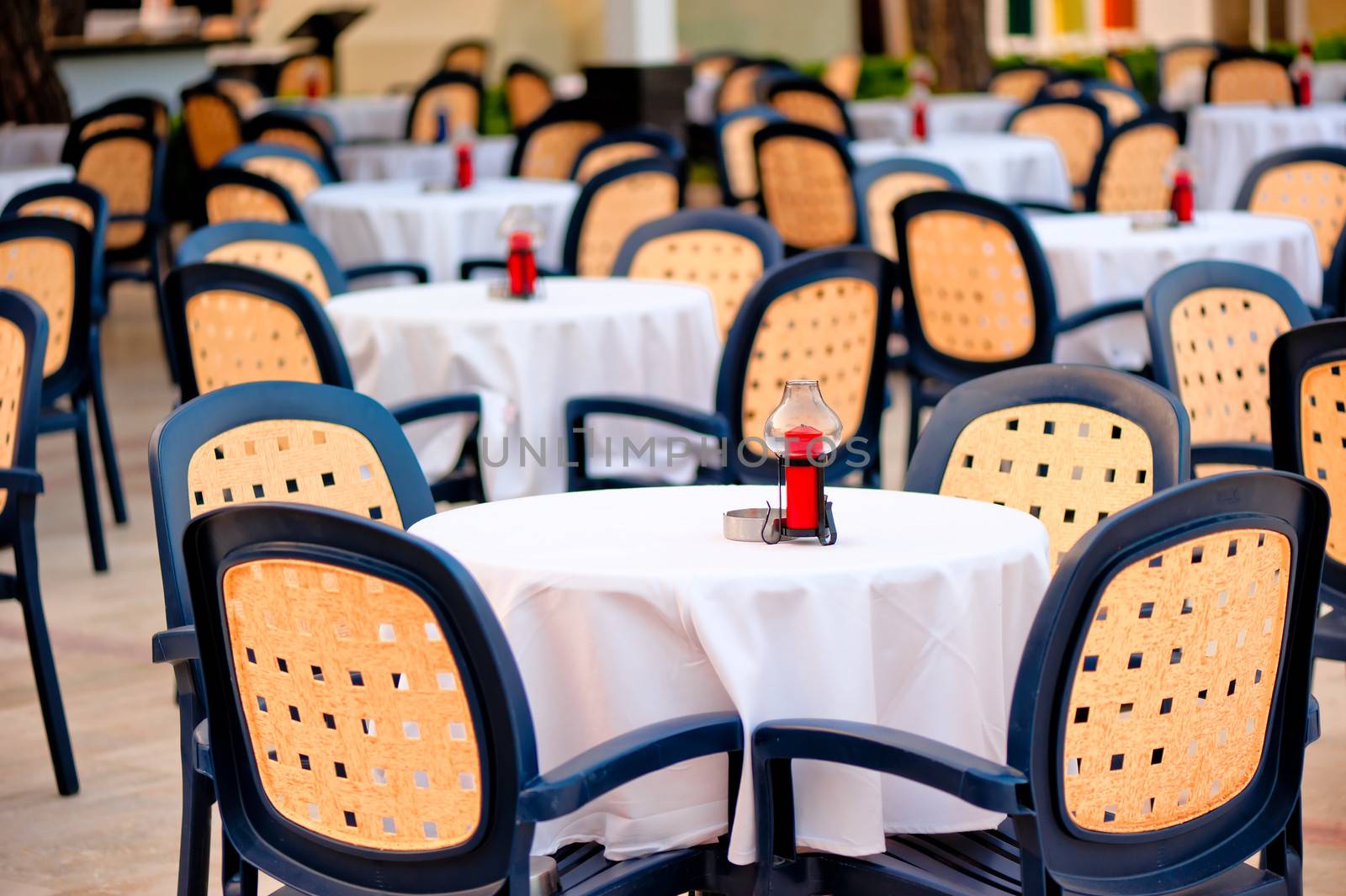 Empty tables in a summer cafe in the morning standing in a row