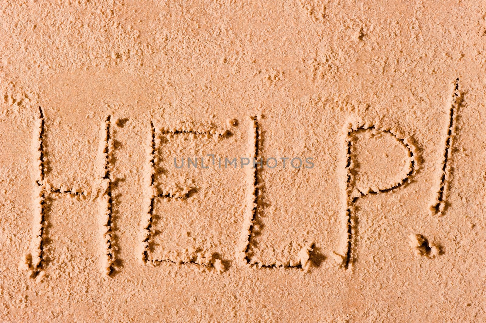 on the wet sand written the word "Help!" by the sea