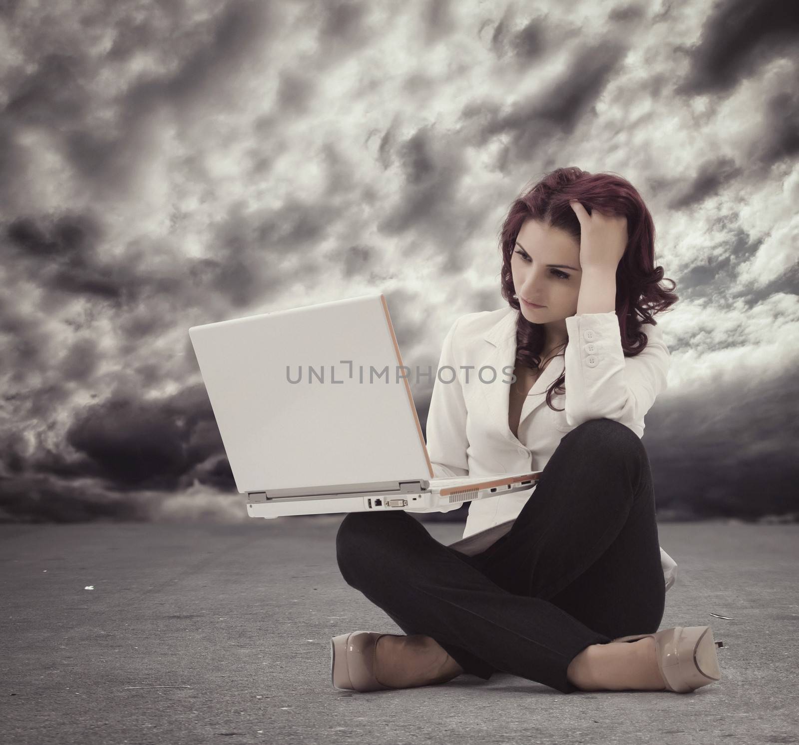 Frustrated Young woman sitting on the floor and  looking at the computer