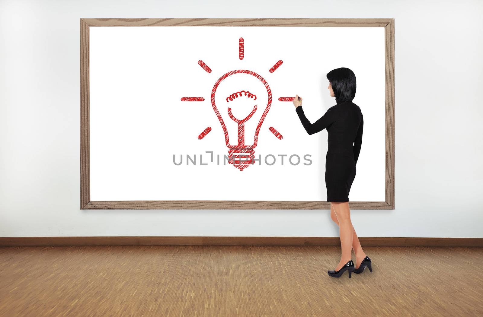 businesswoman drawing lamp on blackboard