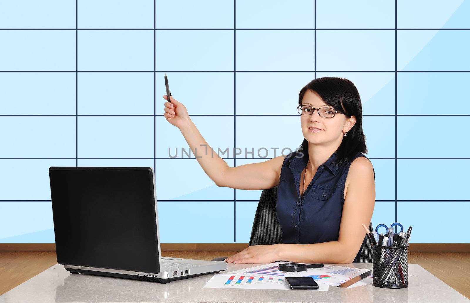 woman in office pointing at plasma panel with chart