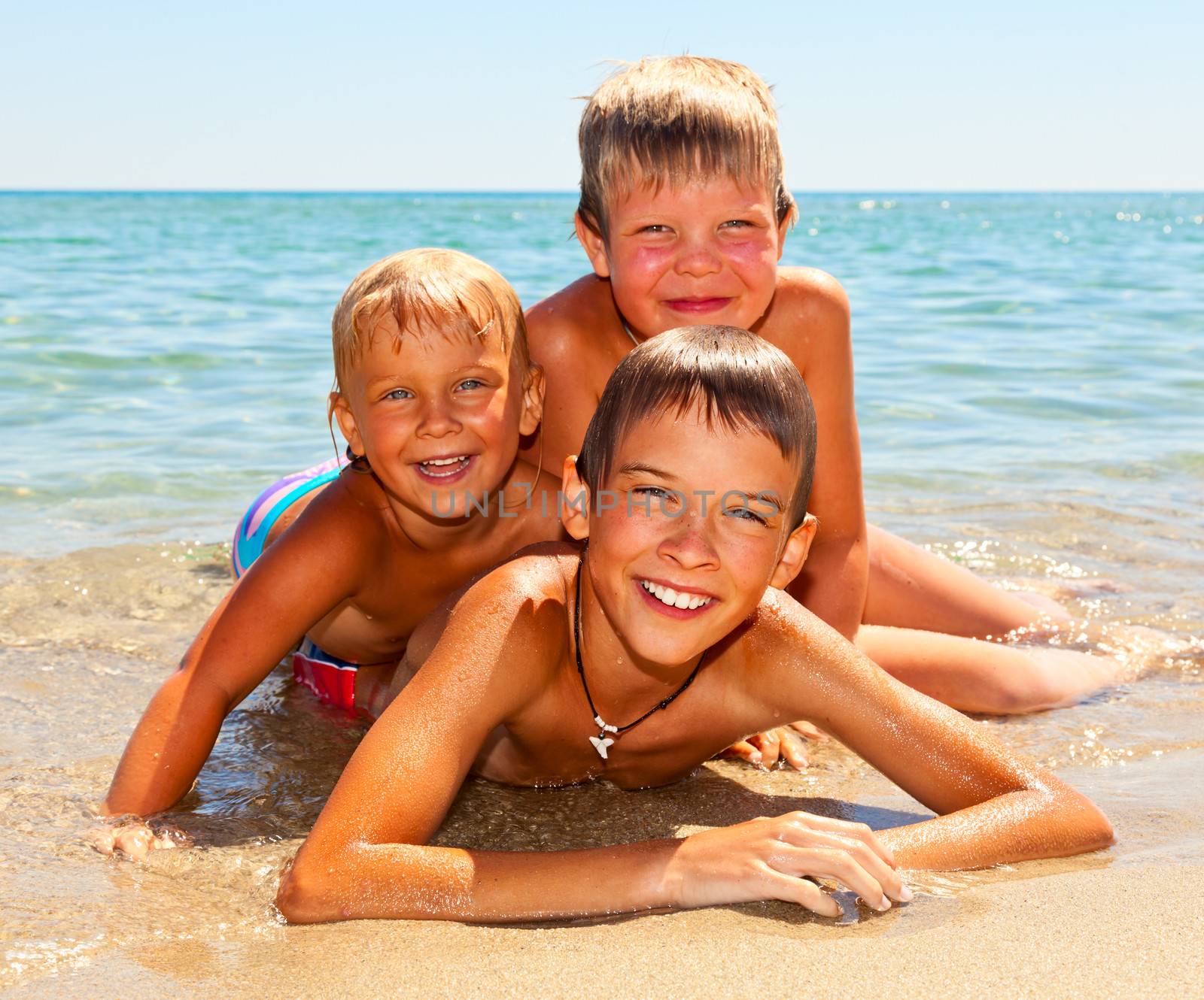 Three kids enjoying summer day on a beach