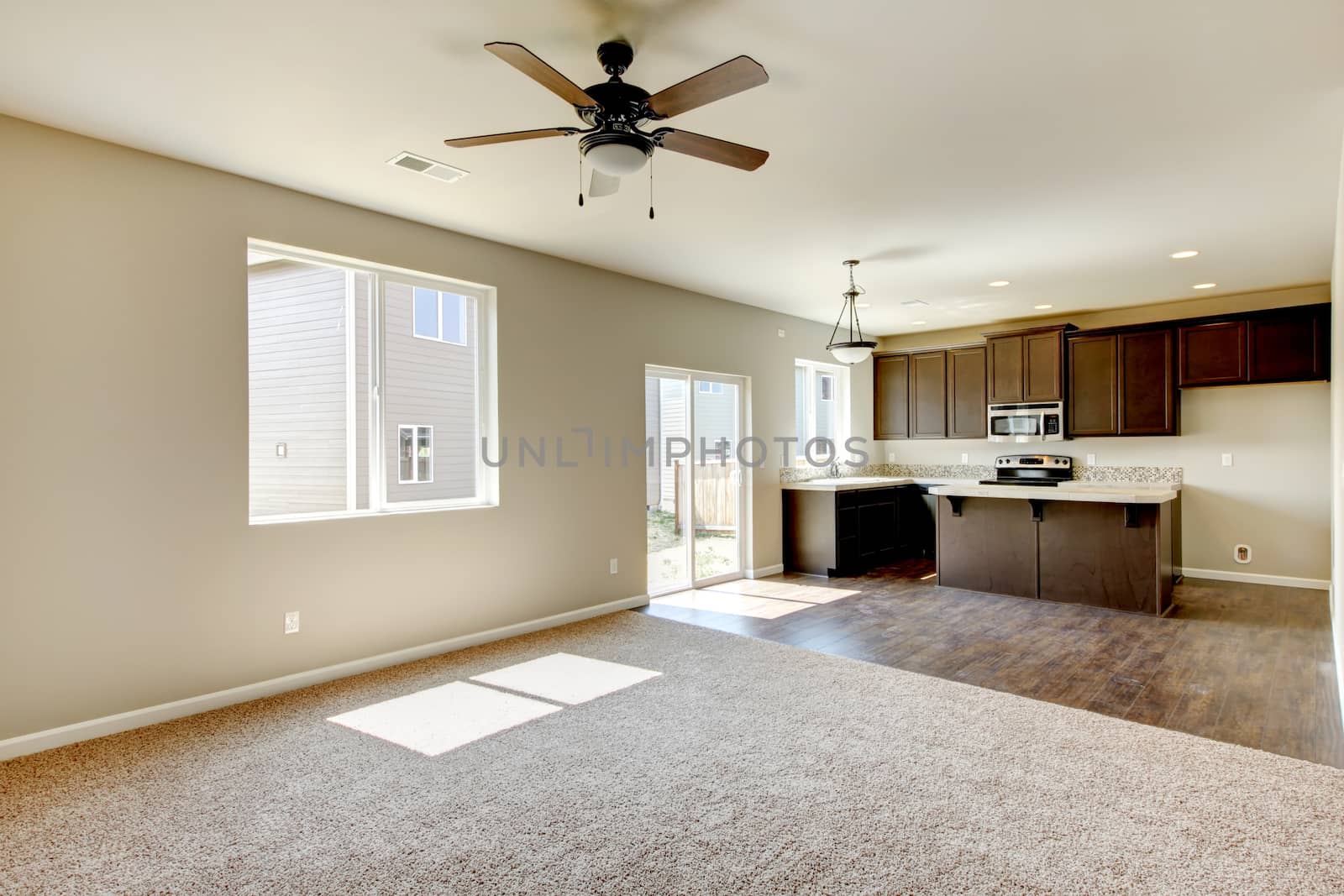 New home kitchen interior with dark brown cabinets and hardwood floors.