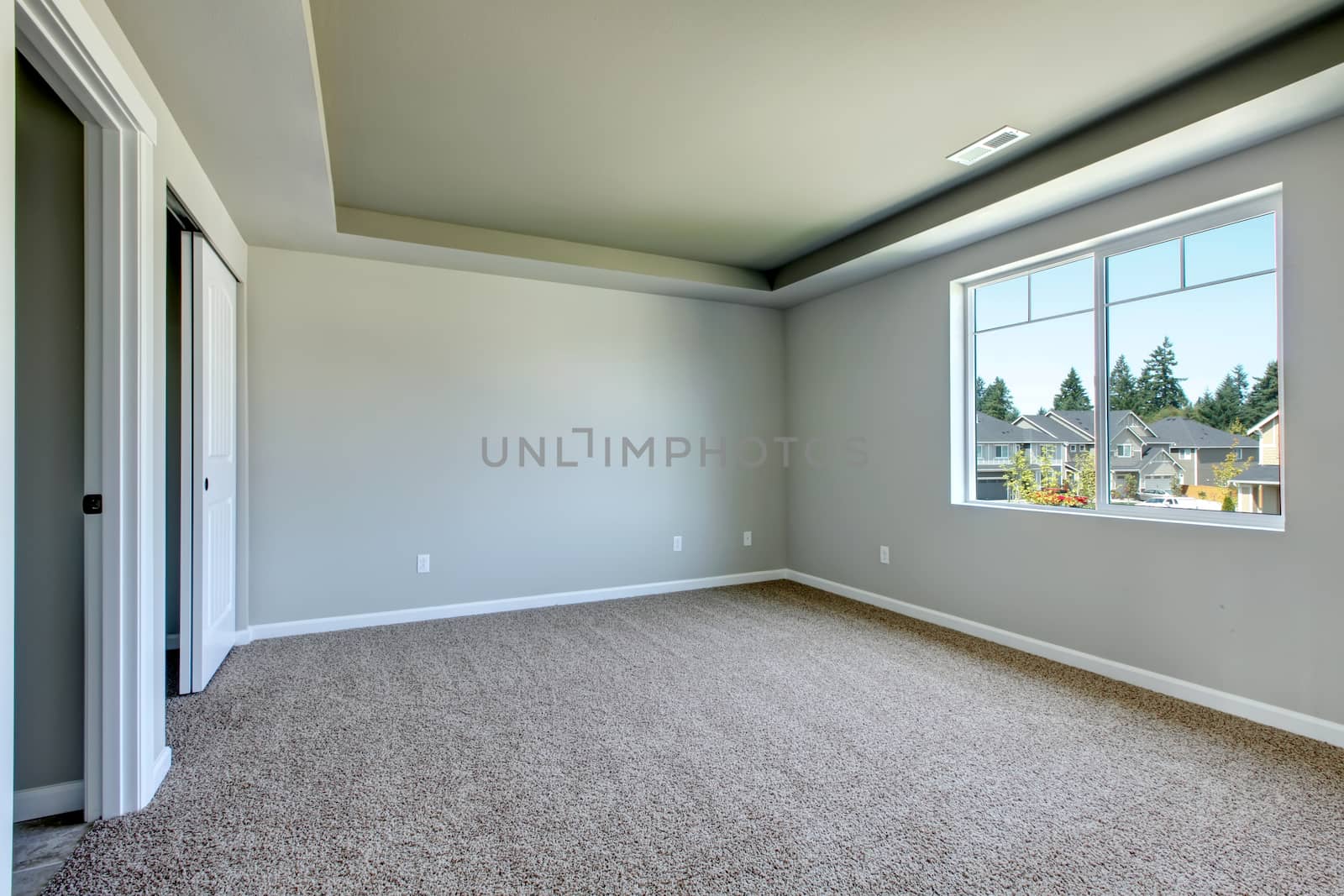 New empty room with beige carpet.. New house development in USA.