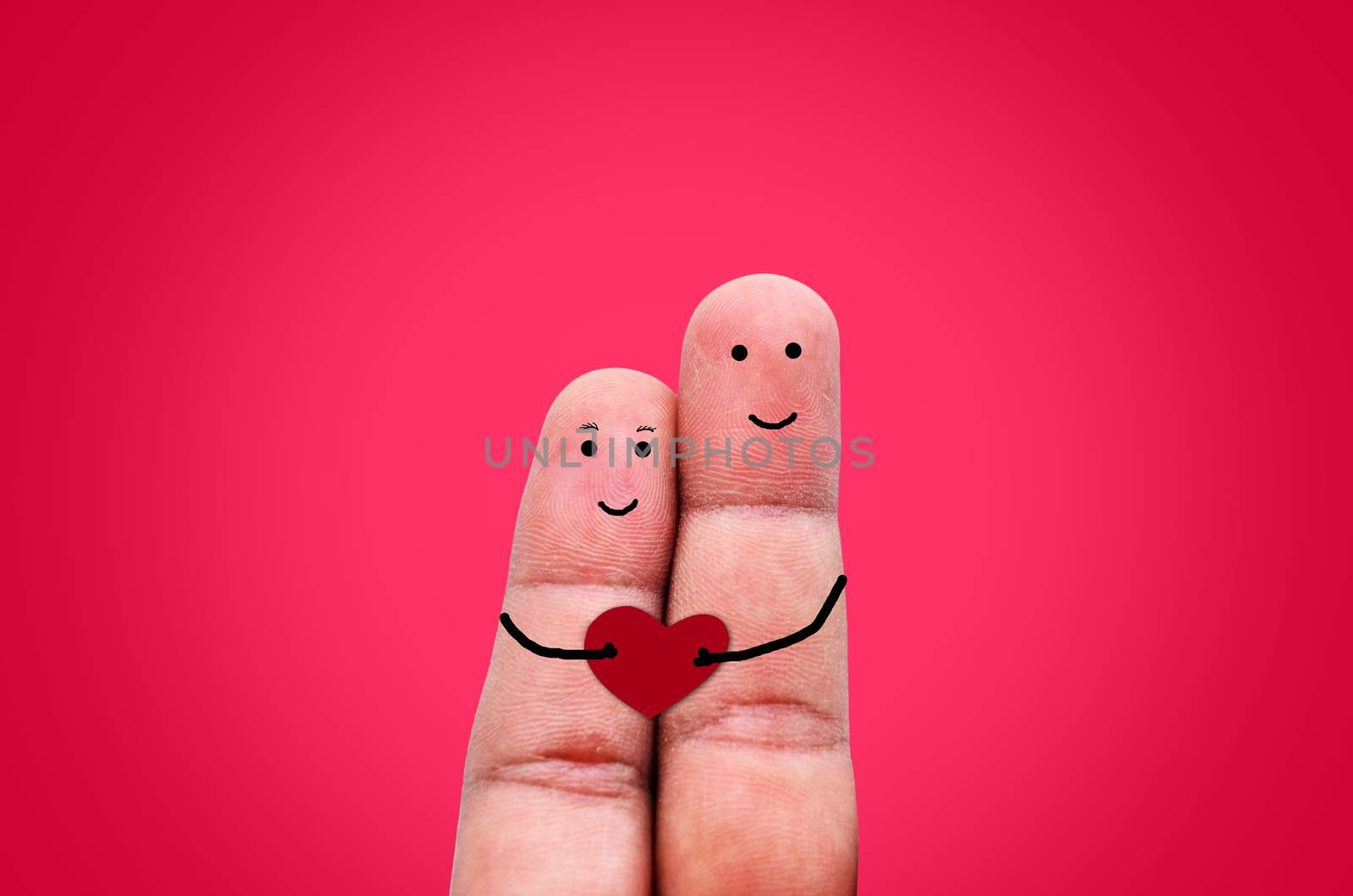 Happy couple in love with painted smiley holding red heart