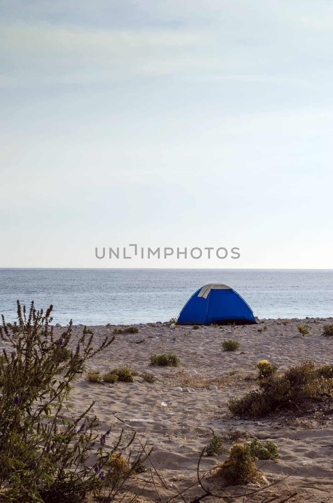 Tent camping on a lonely sandy beach.