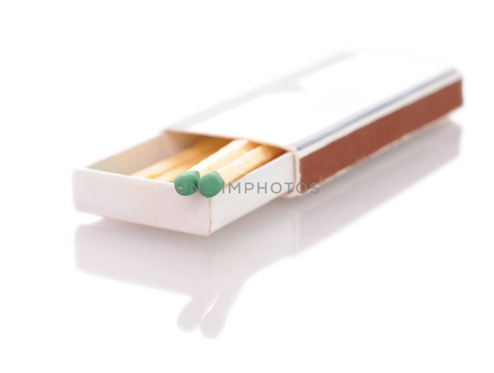 Matchbox with stylish black matches with white heads. Close-up with focus on the match head. Isolated on white background.