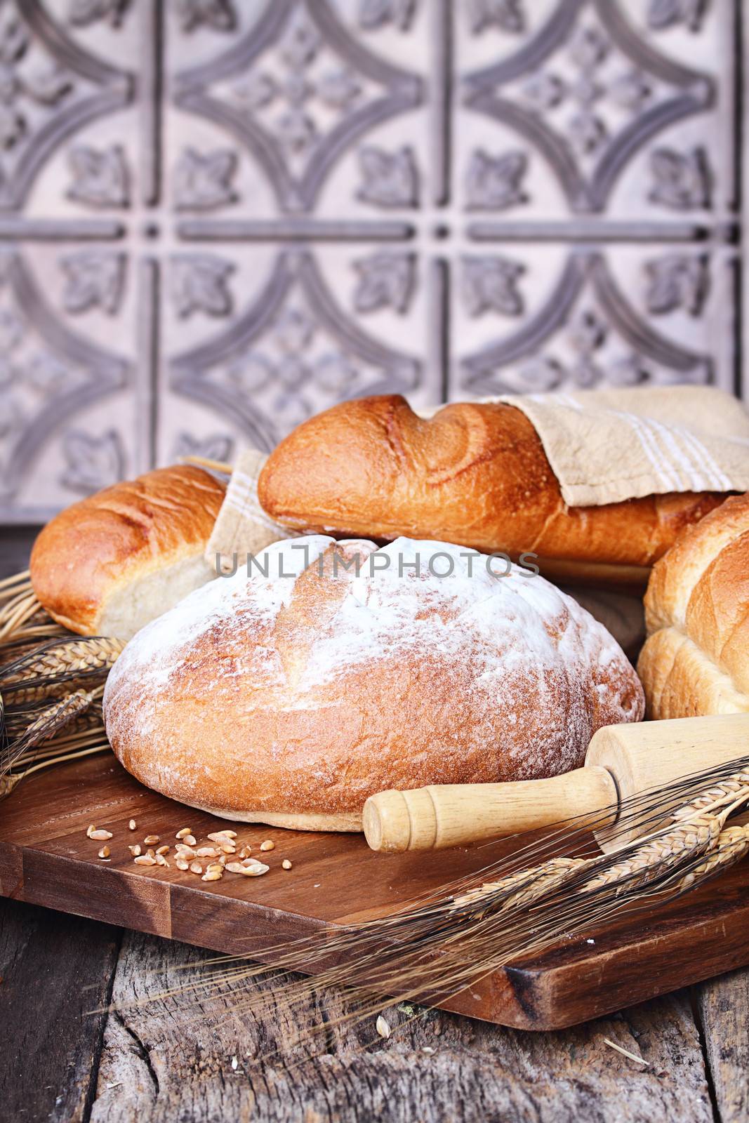 Variety of freshly baked breads and grain against a rustic background.