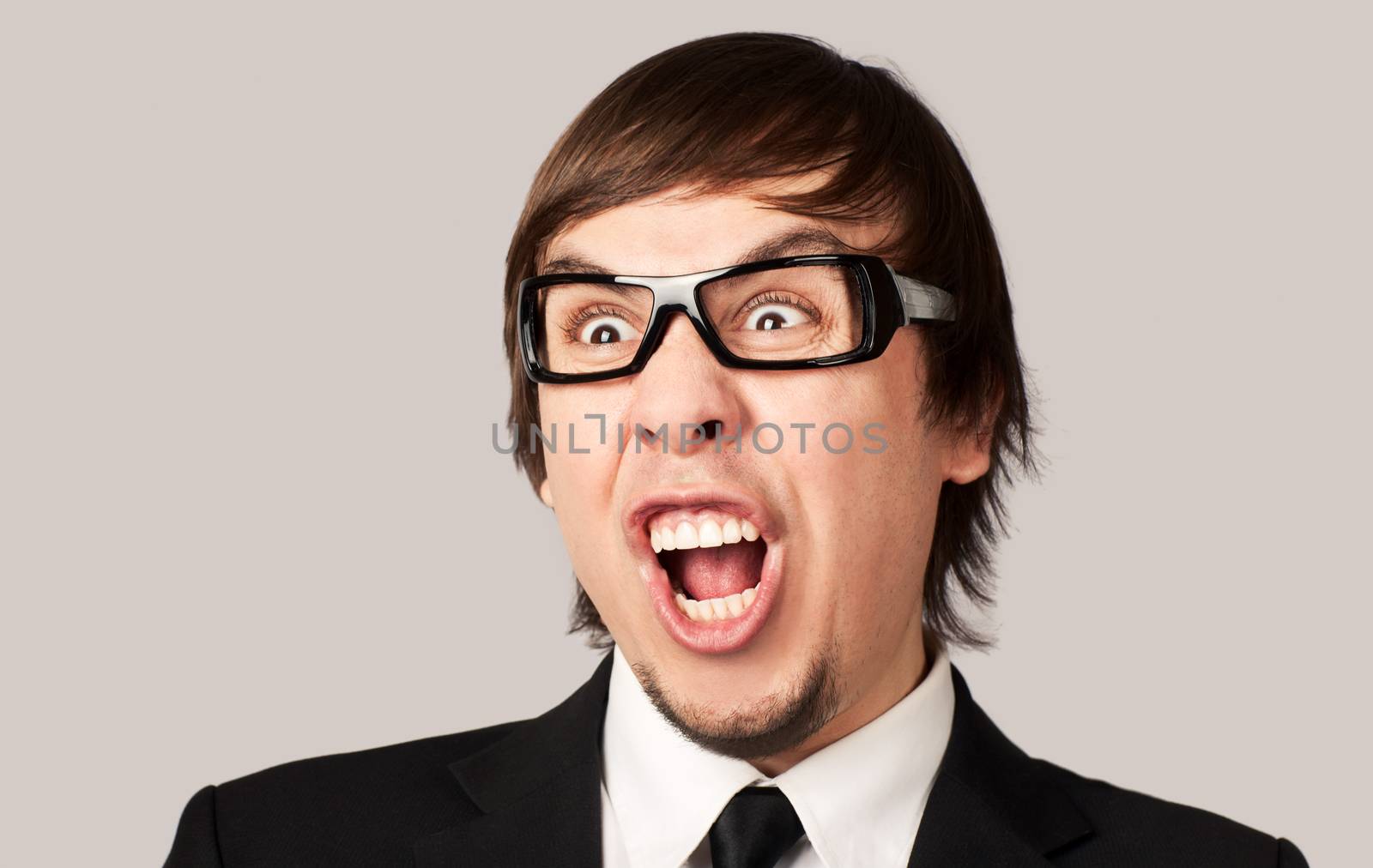 Close-up photo of screaming businessman, on a gray background