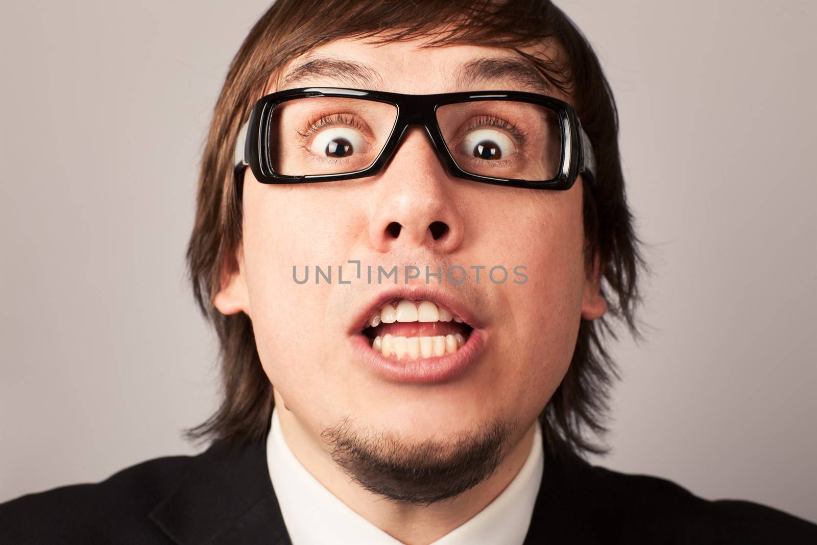 Close-up photo of screaming businessman, on a gray background