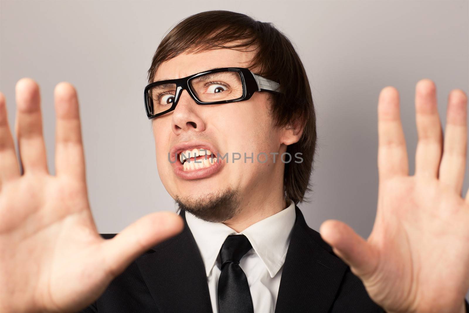 Close-up portrait of businessman, hearing some bad news. On a gray background