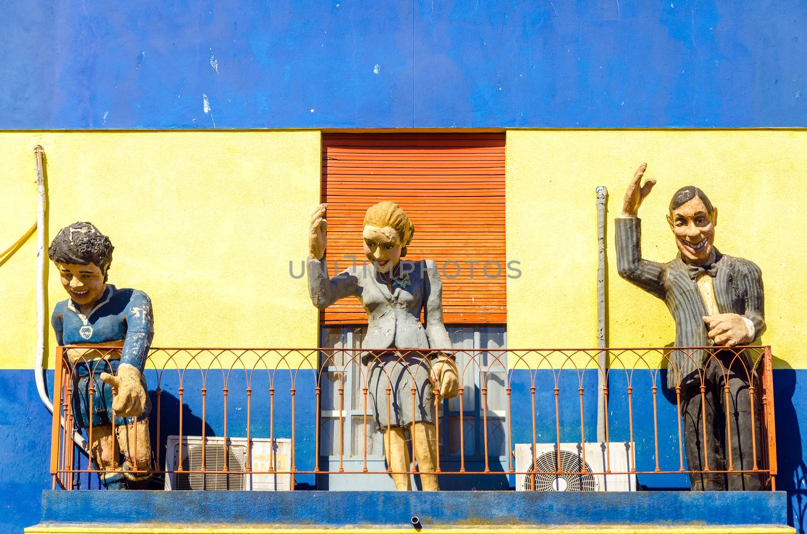 Statues with a yellow and blue wall in La Boca neighborhood of Buenos Aires, Argentina