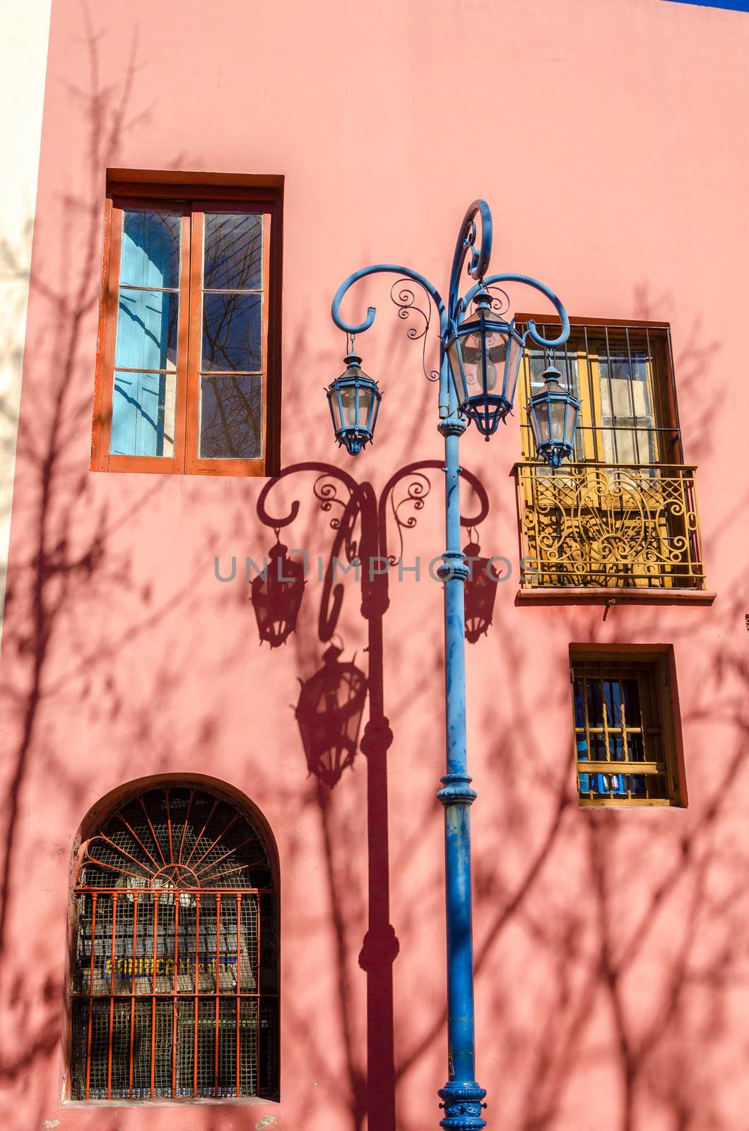 Blue streetlight in La Boca neighborhood of Buenos Aires next to a pink building