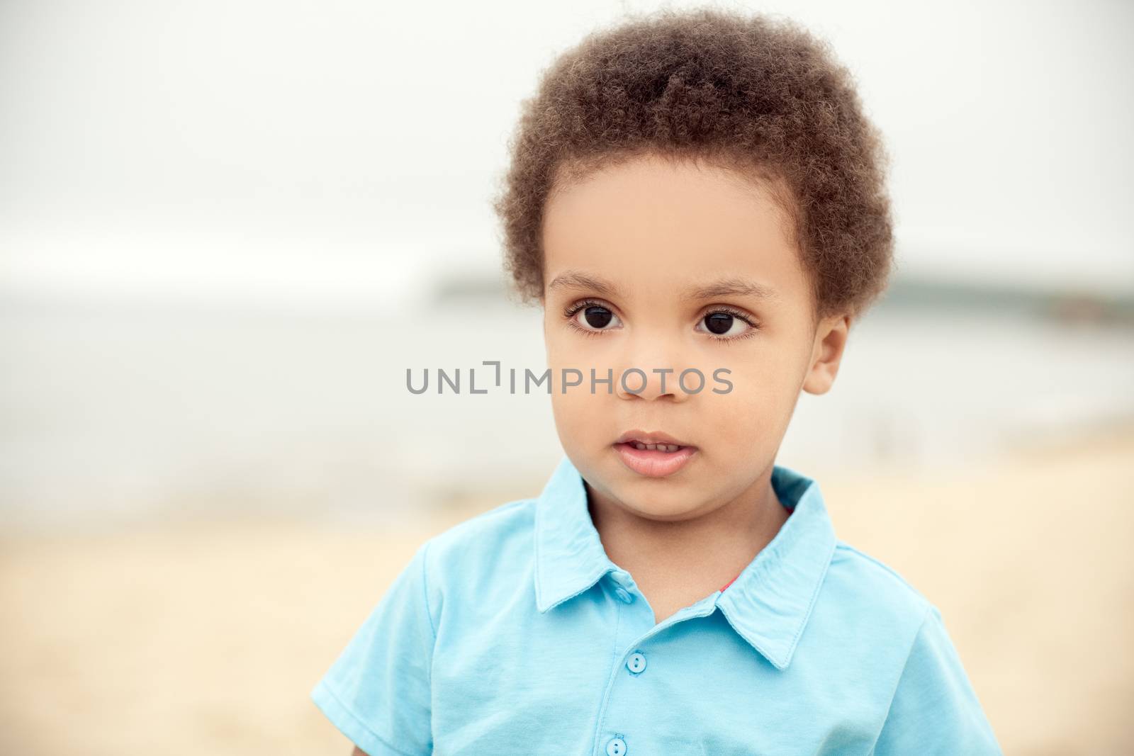 cute african american boy on a background of sand & sea