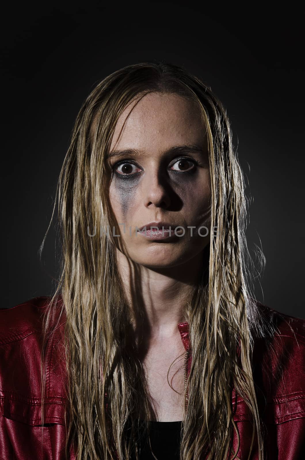 portrait of an abused woman with untidy hair and smudged makeup cropped vertically