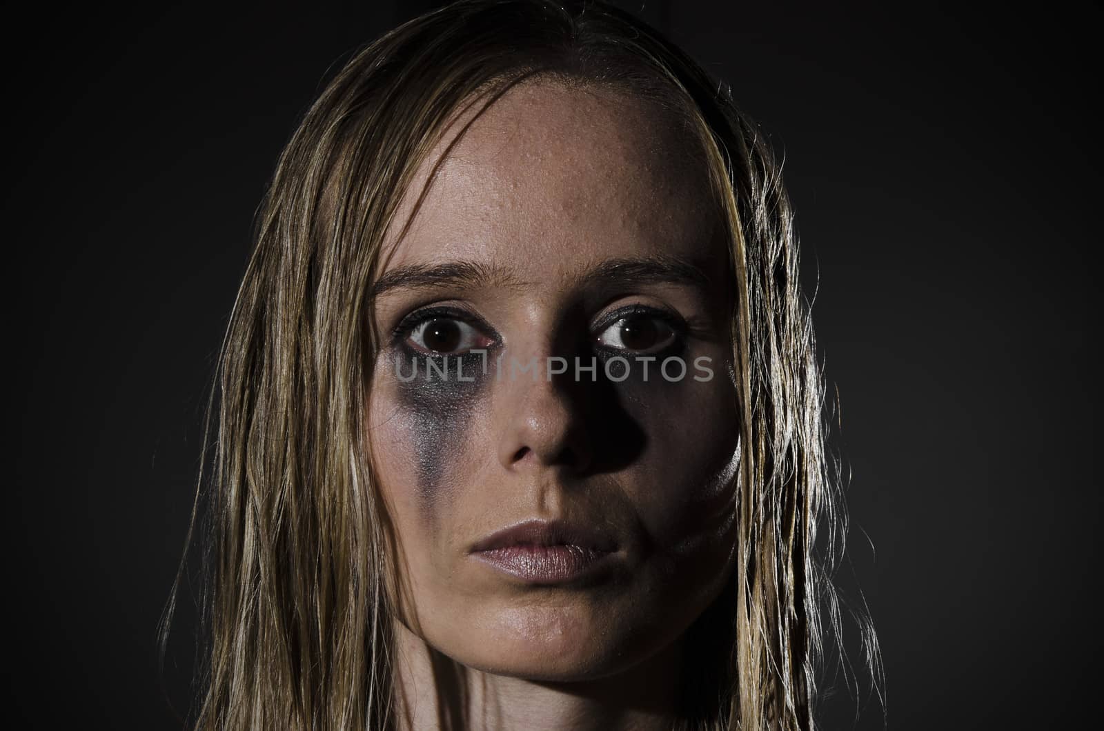 portrait of an abused woman with untidy hair and smudged makeup cropped horizontally