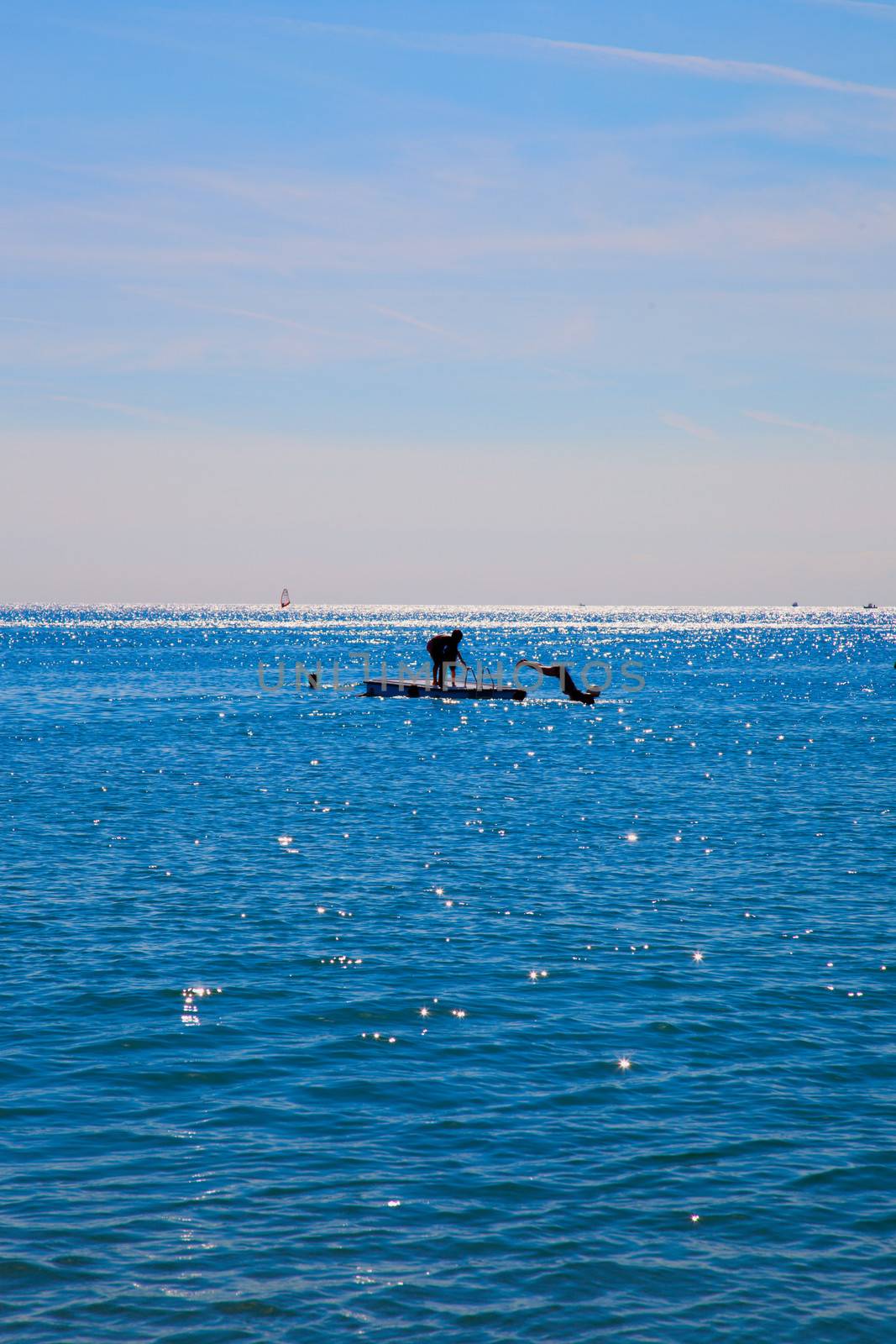 Unrecognizable people diving from a platform in the sea