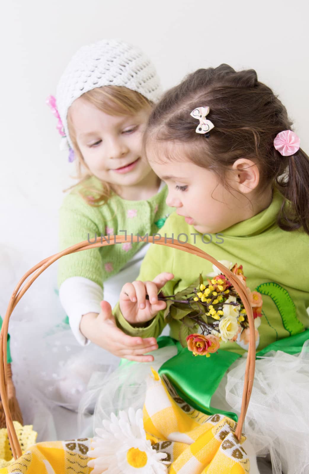 Two cute girls with basket and flowrs playing