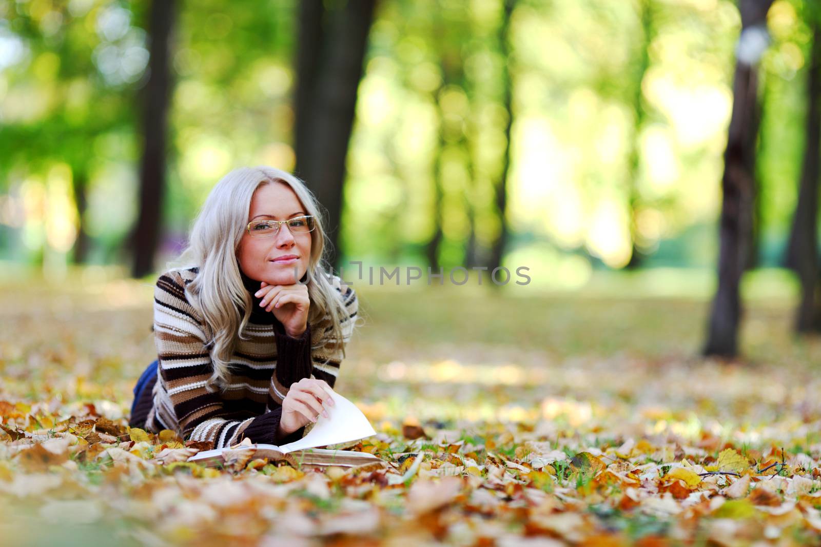 woman read the book in autumn park