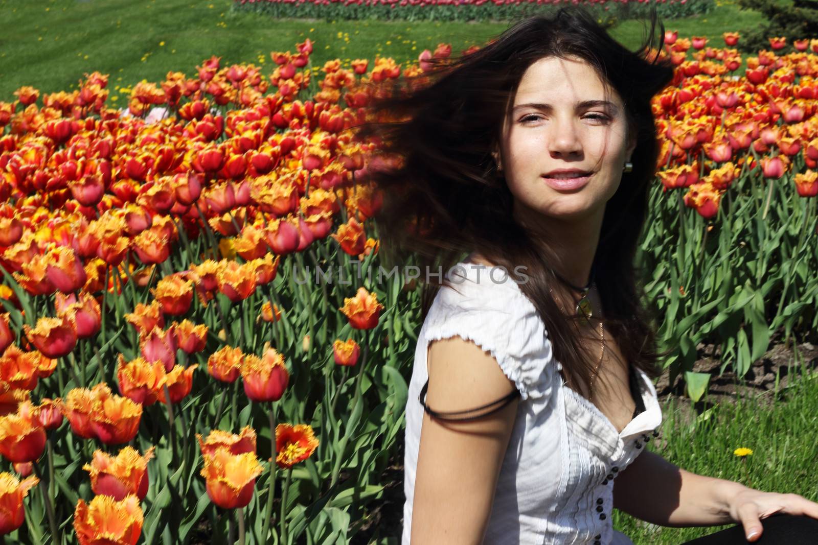Portrait of a young woman on tulips background