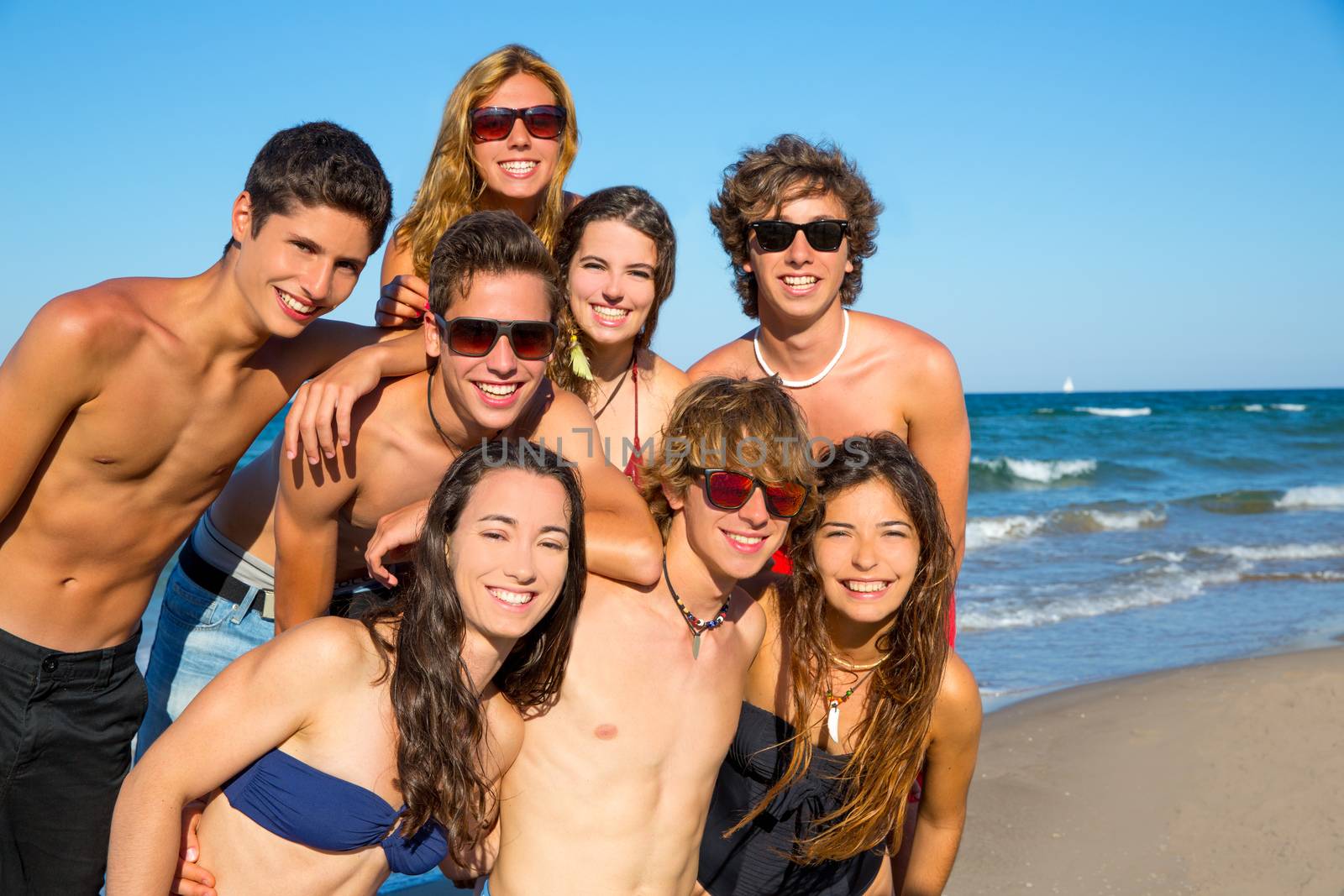Happy teenagers young group together on beach by lunamarina