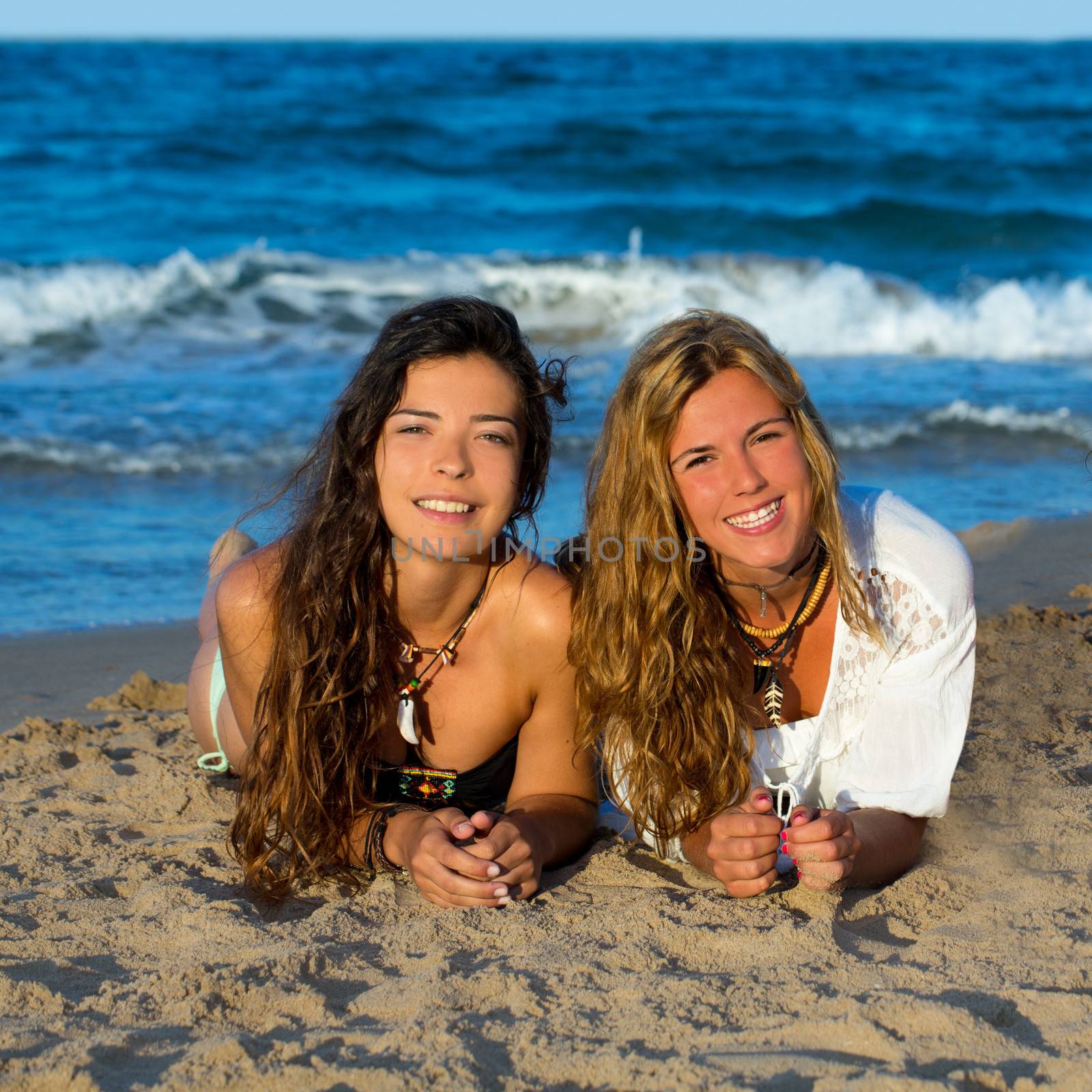 Girls friends having fun happy lying on the beach sand shore
