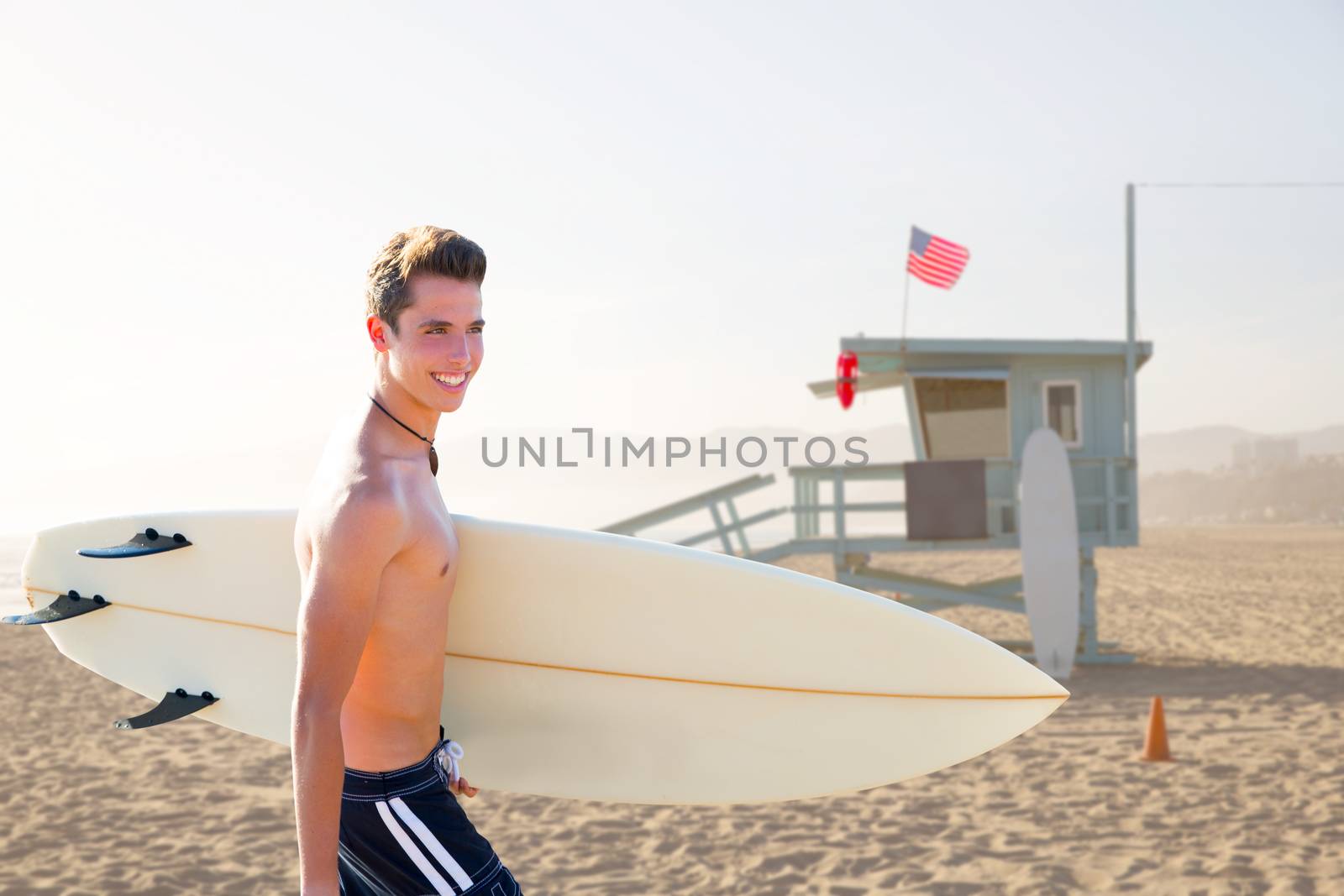 Surfer boy teenager with surfboard in Santa Monica Lifeguard house California