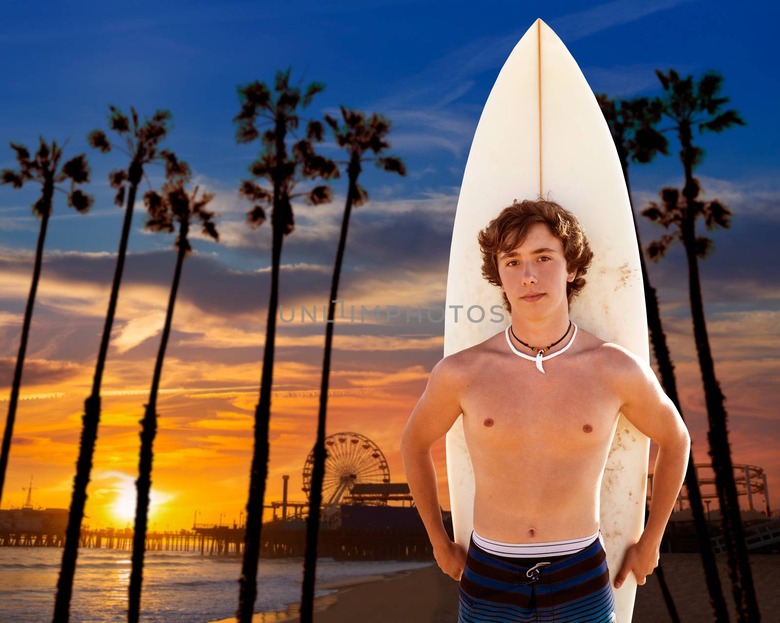 Surfer boy teenager with surfboard in Santa Monica sunset at California