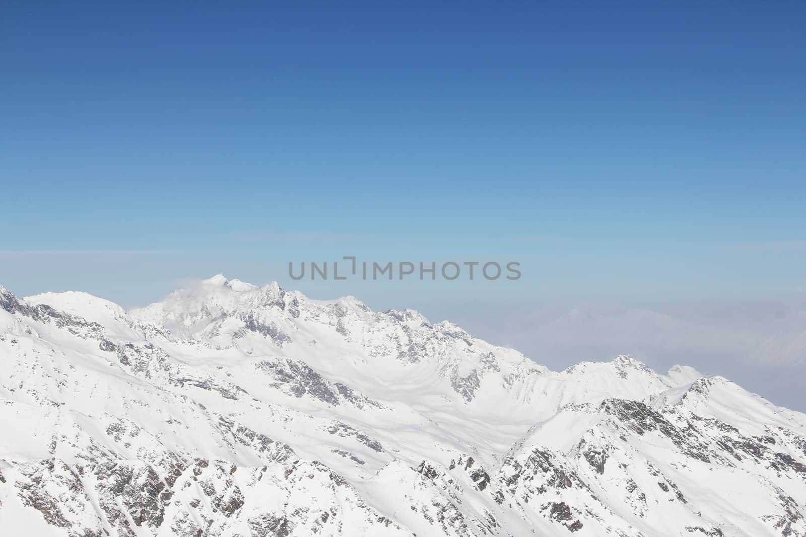 Mountain peaks of winter alps under blue sky