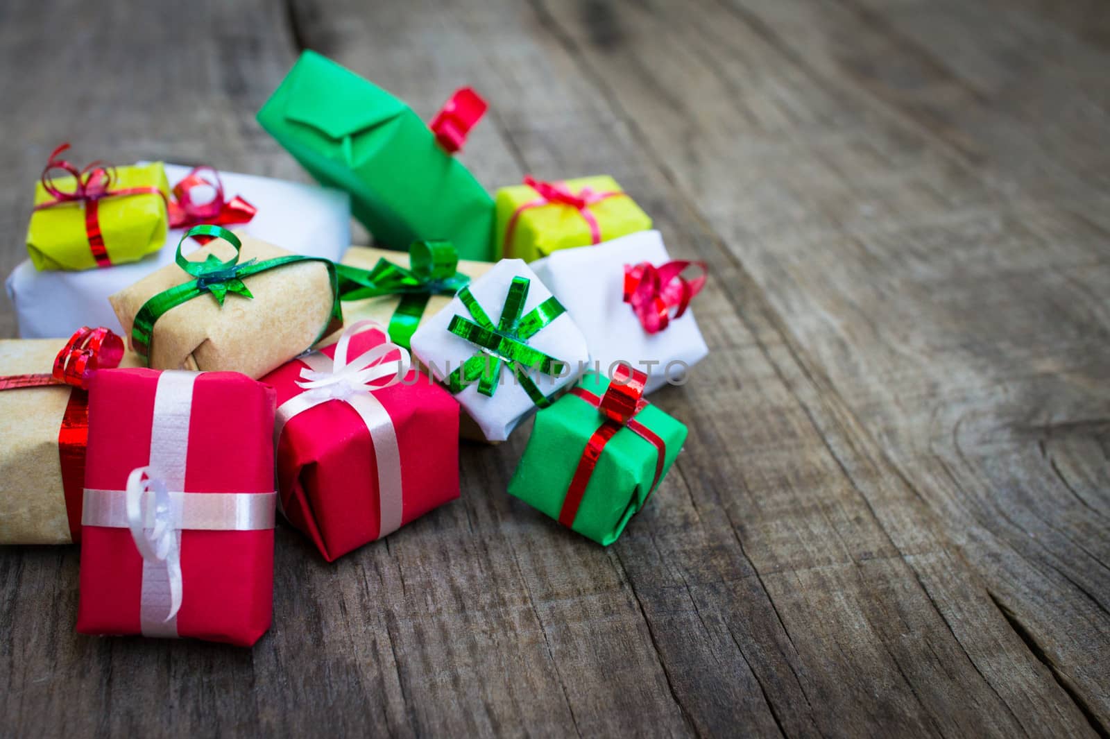 A pile of Christmas presents on wood background.