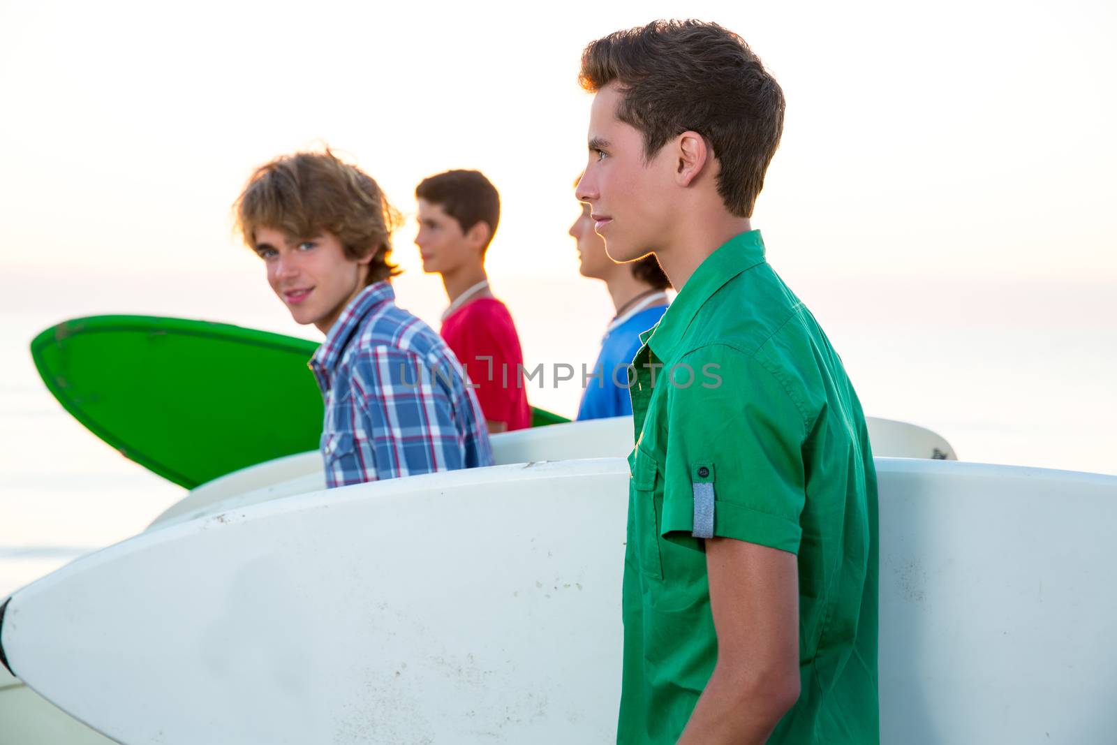 Surfer teenager boys walking at beach shore by lunamarina
