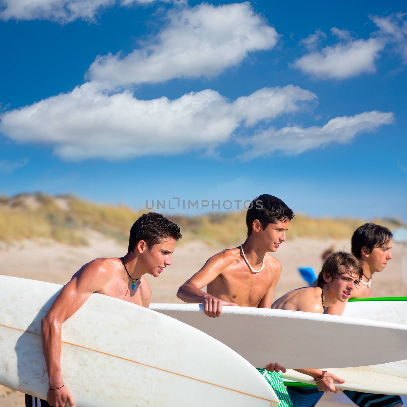 Surfer teen boys talking on beach shore by lunamarina