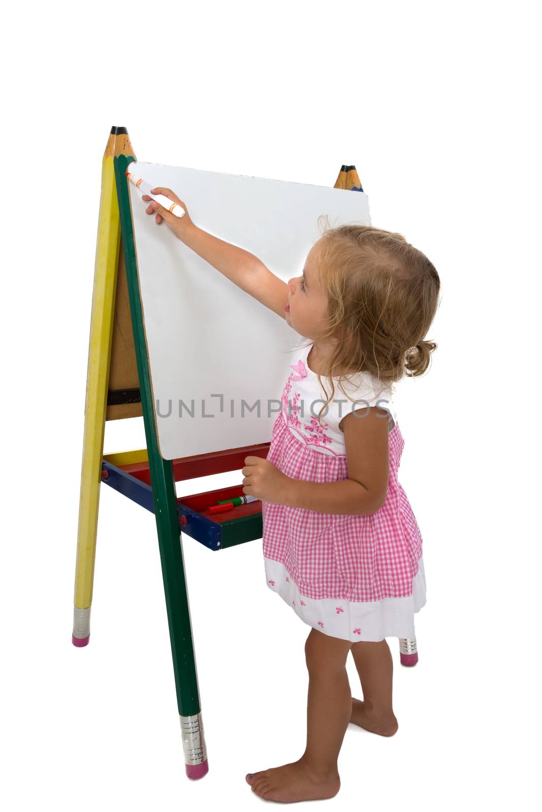 Creative cute little girl staring to draw on an easel, isolated on white background
