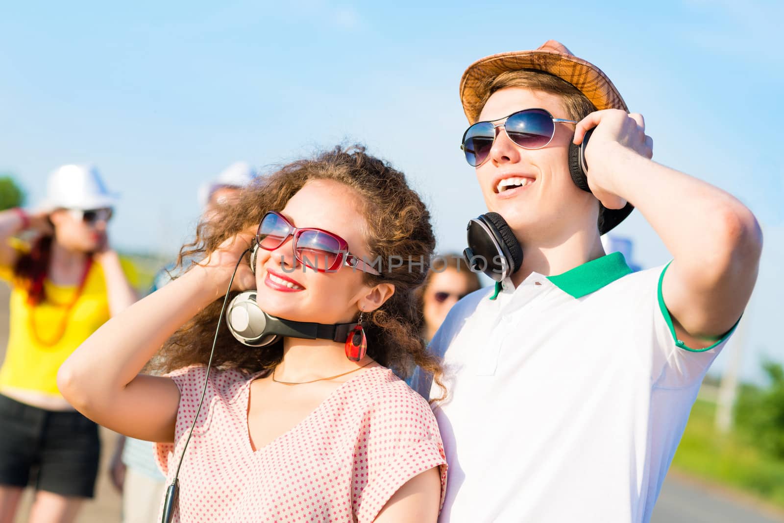 young couple standing on the road, having fun with friends