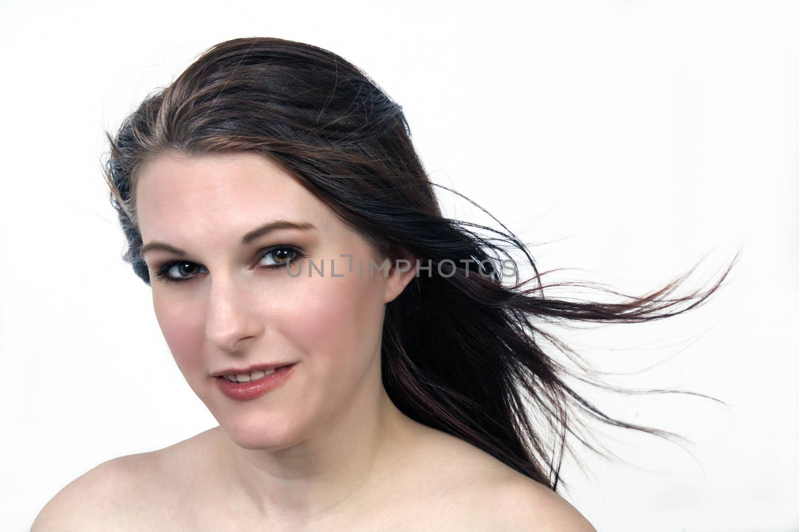 A close-up of a lovely young brunette with a friendly smile, isolated on a white background.