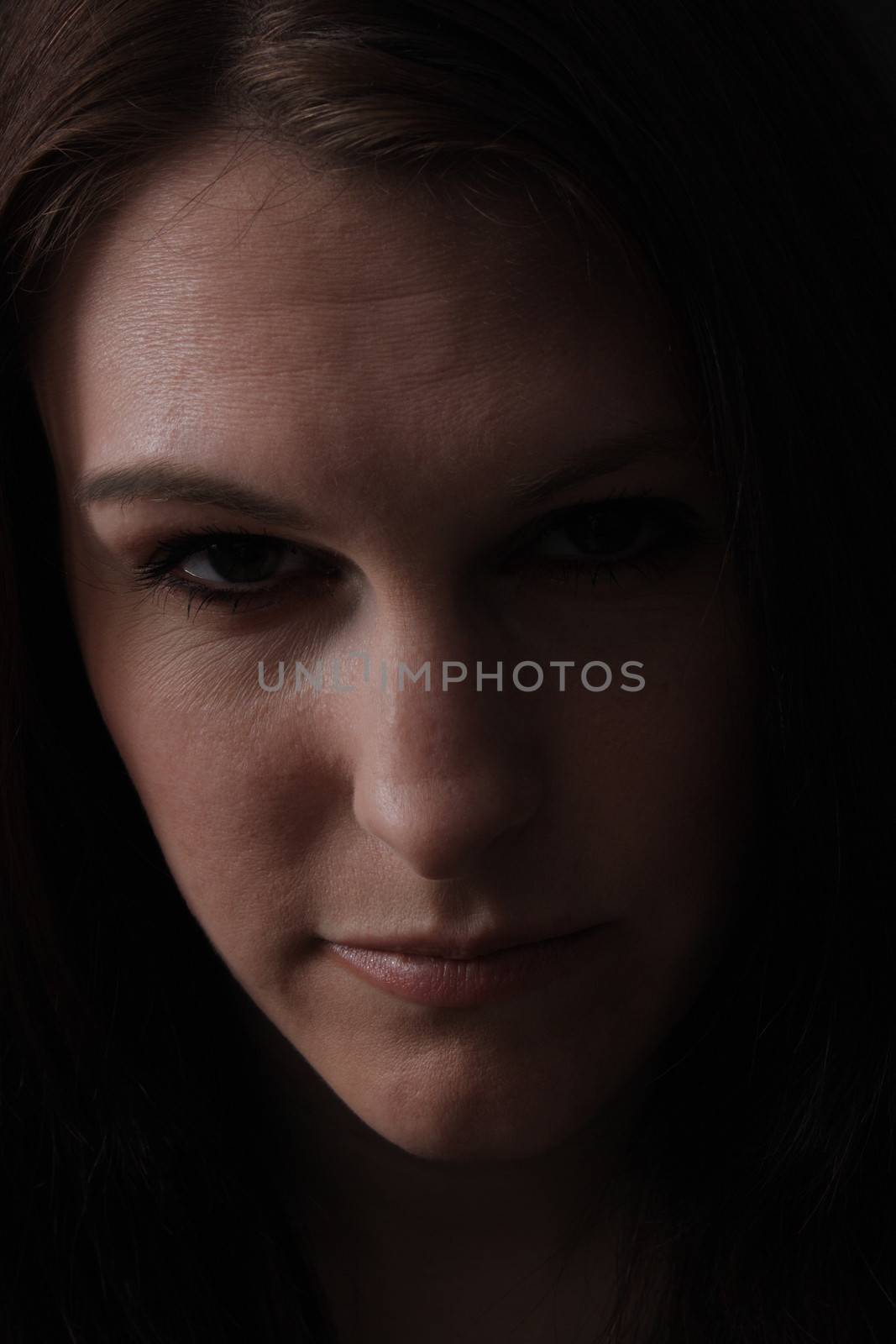 A low-key closeup of a beautiful, young brunette.