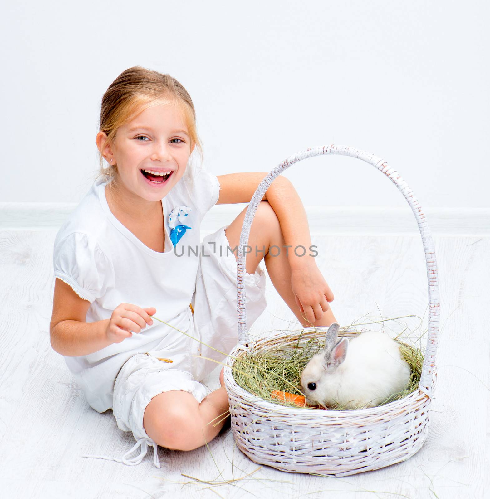 Cute smiling Little girl with a rabbit in basket