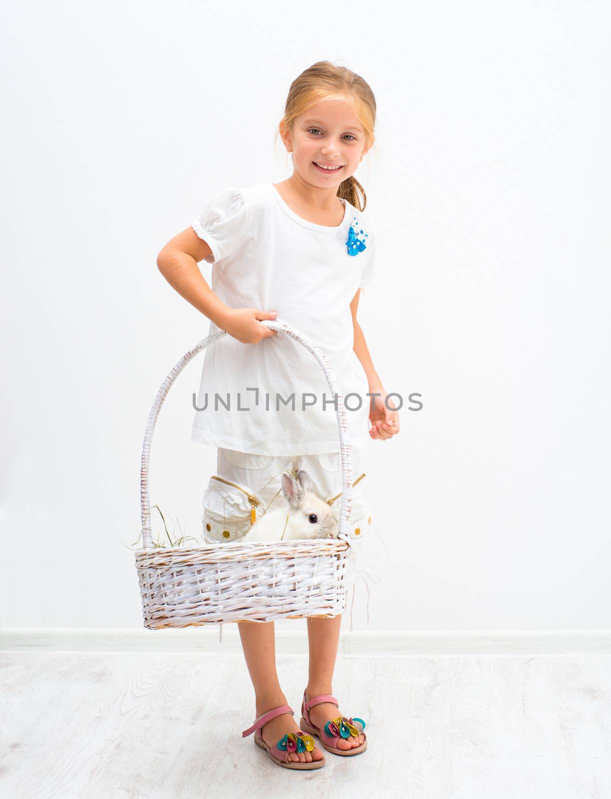 Little girl with a rabbit in basket
