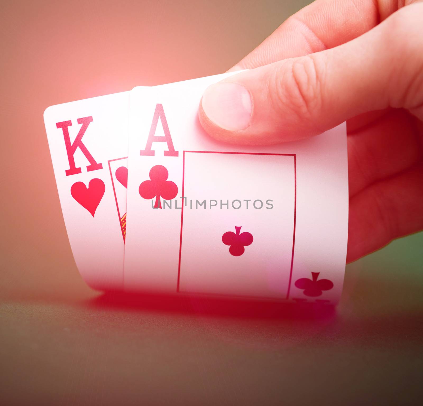 playing cards in hand on a green table casino