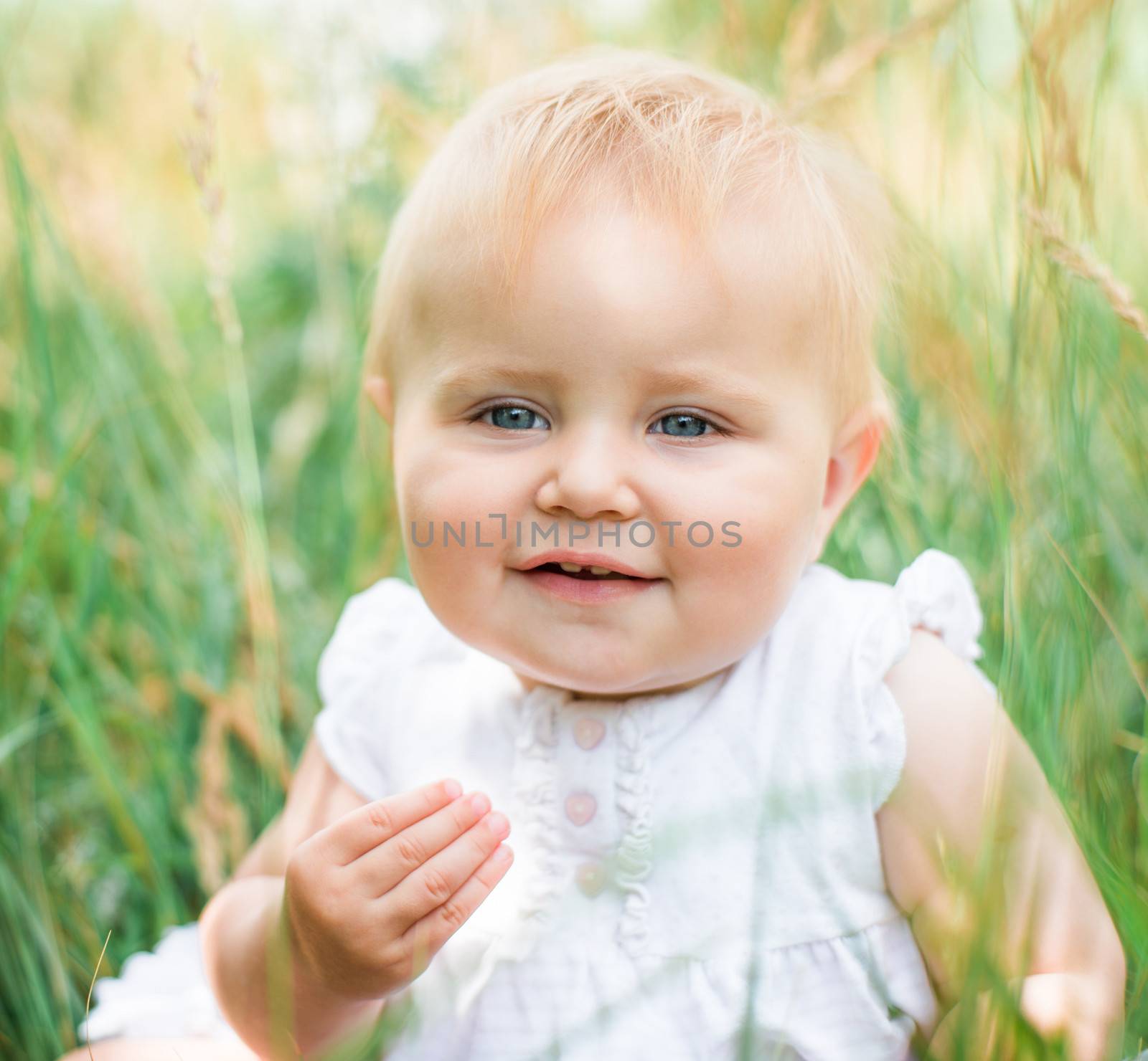 cute beautiful baby's face in green grass