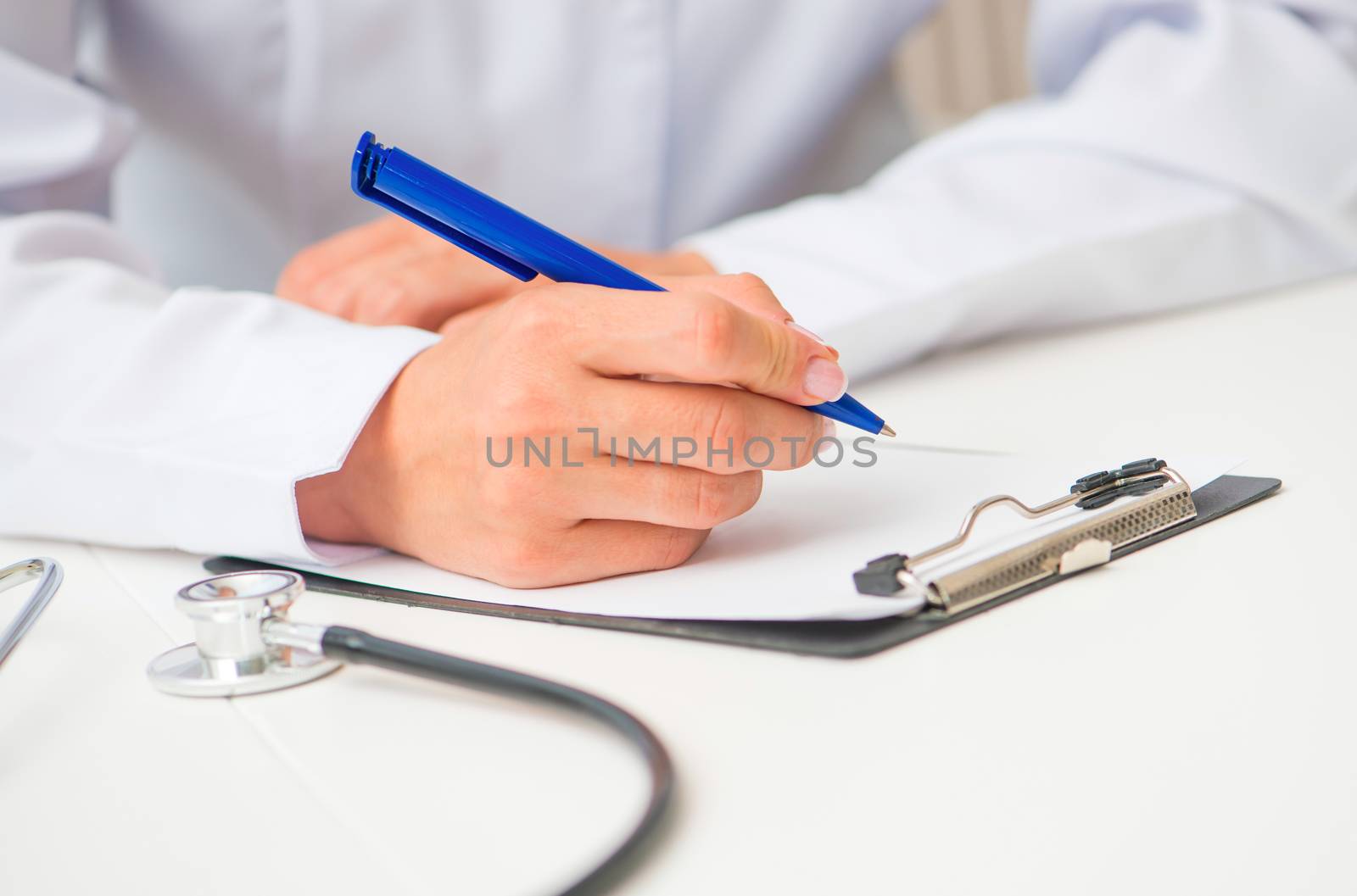 doctor's hands with a plane-table and pen on white table