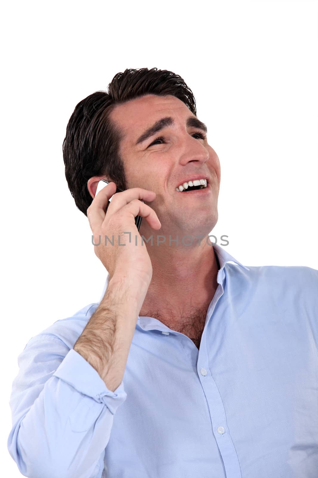 A businessman laughing over the phone.