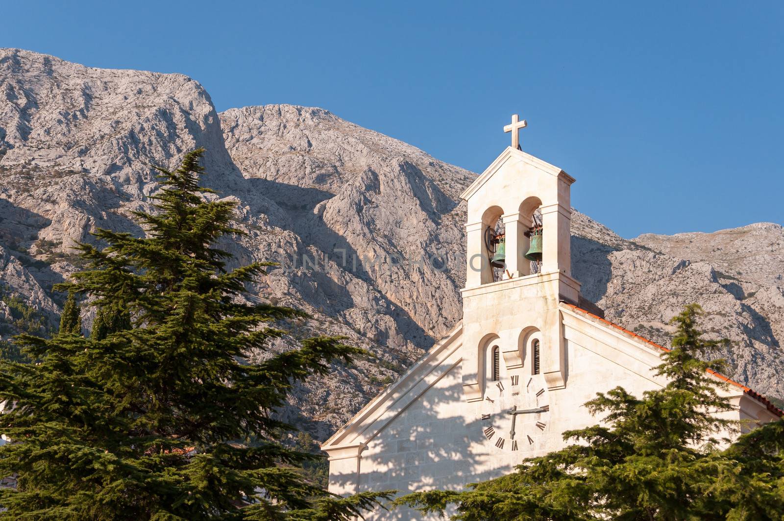 St Nicholas Church's bells with mountains in background in Baska Voda in Croatia.