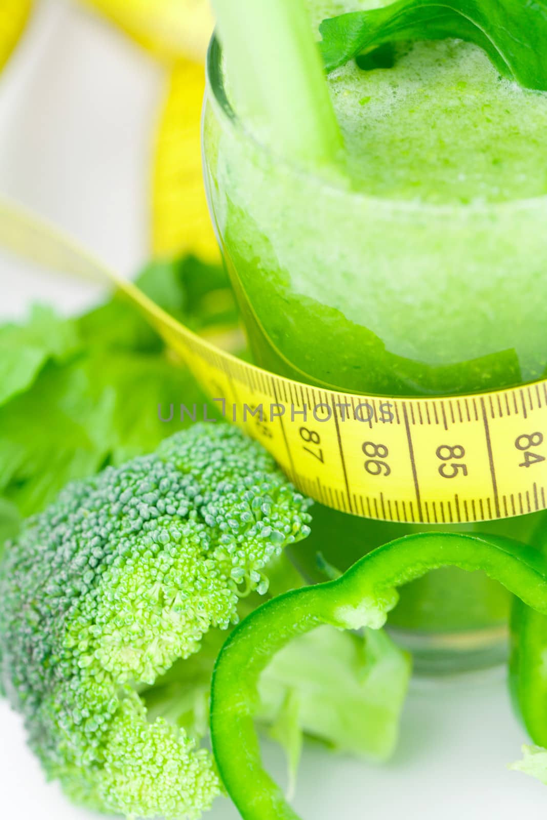 measuring tape,broccoli,pepper,celery and glass with celery juice 