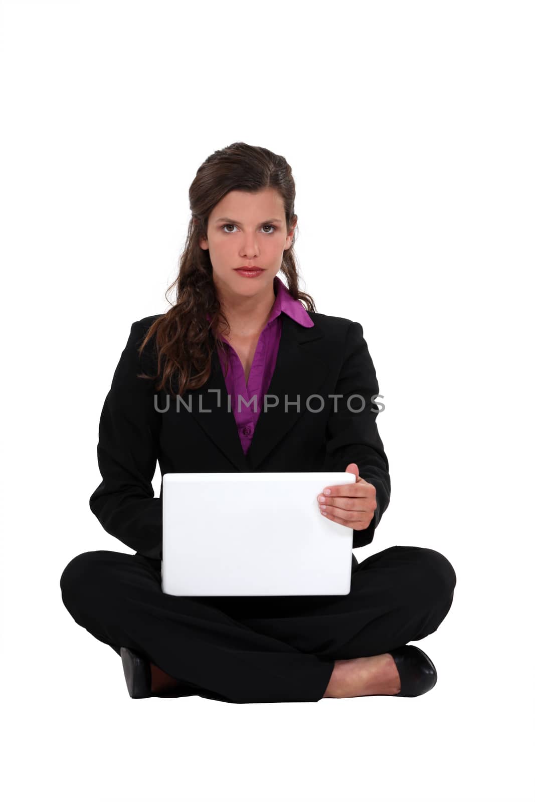 Brunette businesswoman sat cross-legged on the floor by phovoir