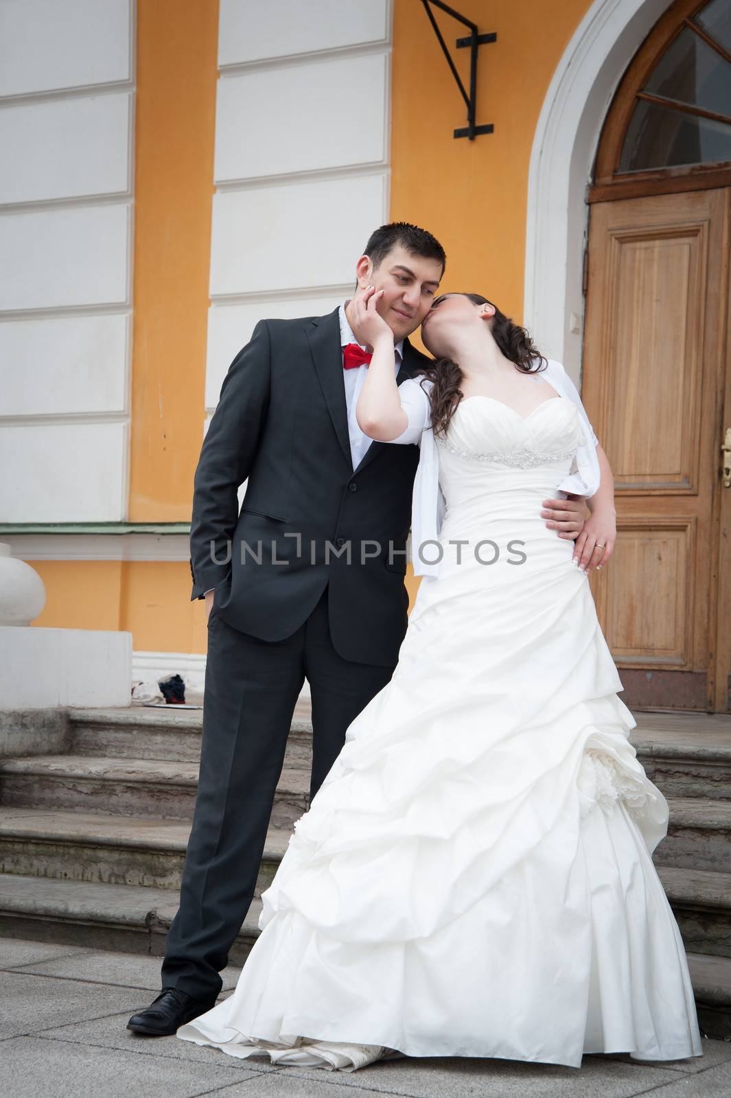 bride and groom standing in front of the palace