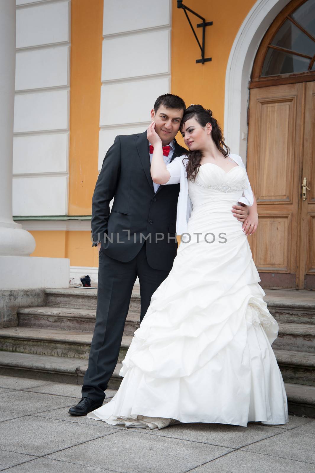 bride and groom standing in front of the palace