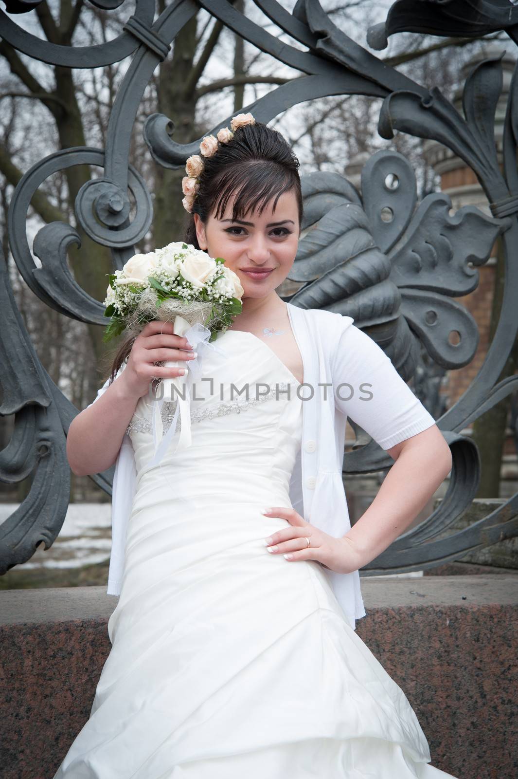 bride with bouquet in park fence